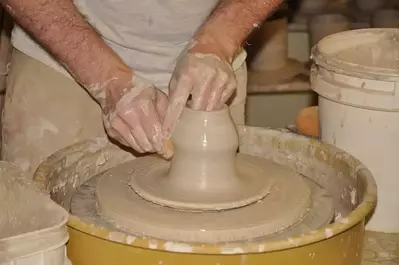 person making pottery on a pottery wheel